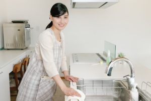 キッチンの汚れをすぐに拭き取る女性